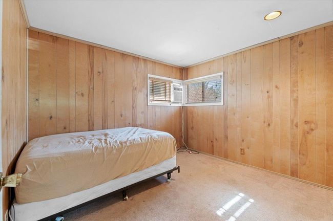 Bedroom featuring carpet flooring and wood walls | Image 12