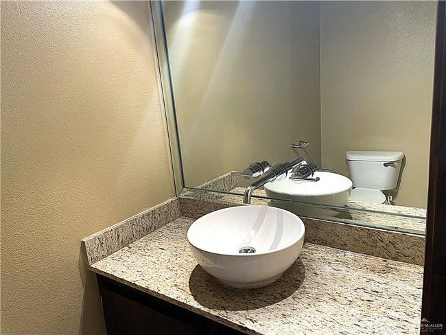 Half bathroom with a textured wall, vanity, and toilet | Image 10