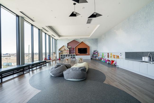 Playroom with a raised ceiling, wood finished floors, visible vents, and expansive windows | Image 33
