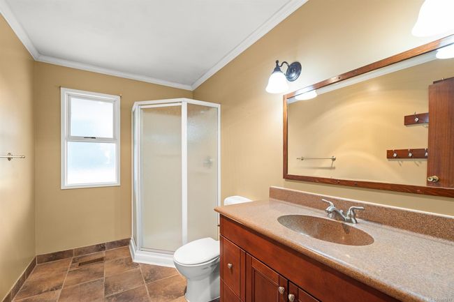 Full bath with toilet, crown molding, vanity, a stall shower, and baseboards | Image 37