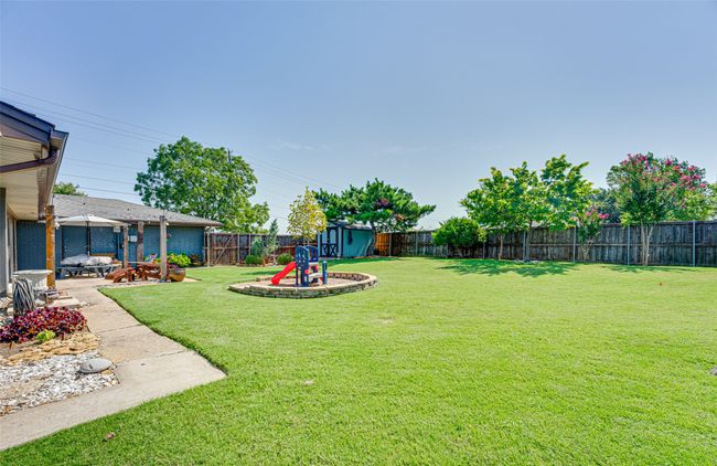Fenced backyard with a playground and a patio area | Image 33