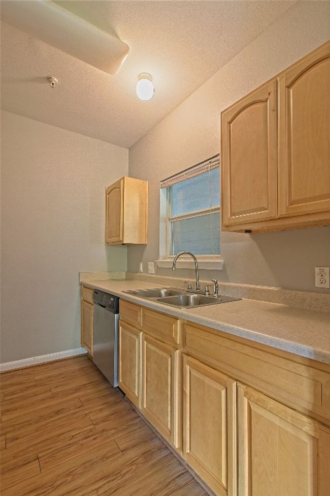 Kitchen featuring light brown cabinetry, dishwasher, light wood-style floors, and light countertops | Image 19