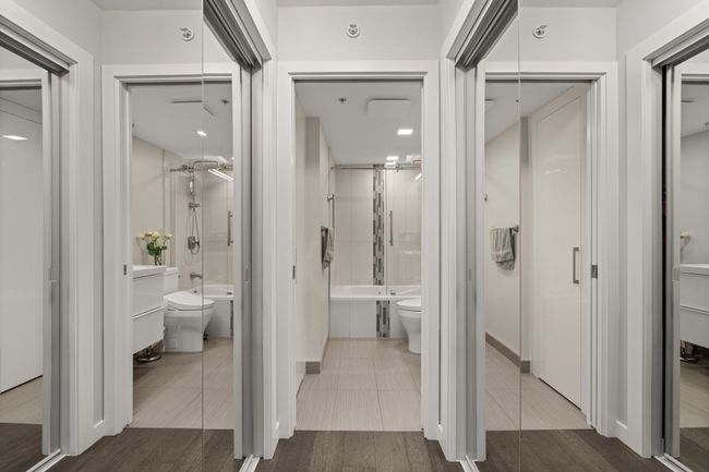 Bathroom featuring wood finished floors, bath / shower combo with glass door, toilet, and vanity | Image 28