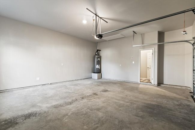 Garage featuring a garage door opener and water heater | Image 26