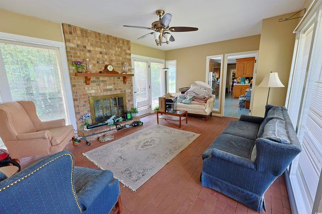 Living area with a ceiling fan and a fireplace | Image 15