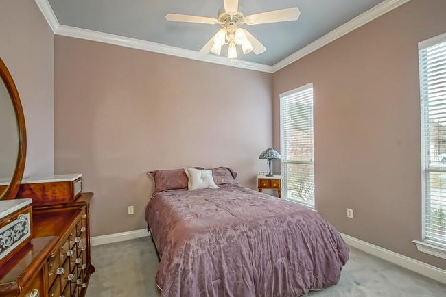 Guest Bedroom 1 faces front of house. Ceiling fan/light. | Image 23