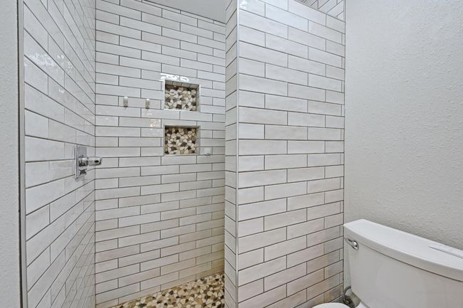 Full bath featuring tiled shower and toilet | Image 8