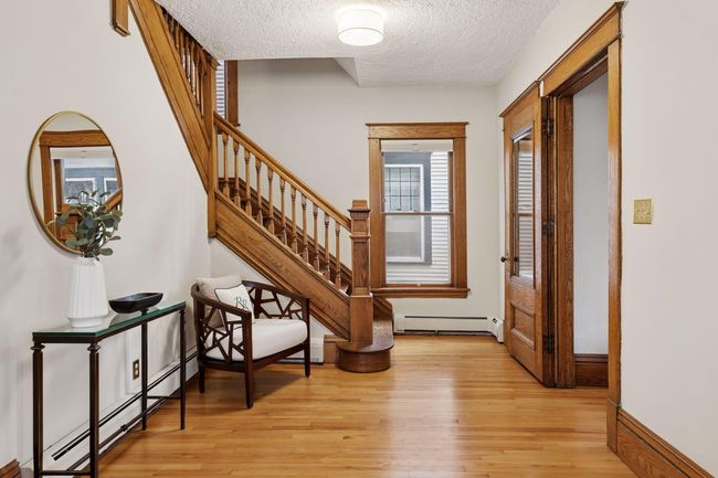 The gracious foyer features gleaming hardwood floors and rich natural woodwork. | Image 4