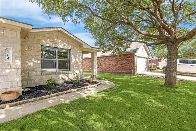 View of the front of the home and front yard with large tree | Image 30