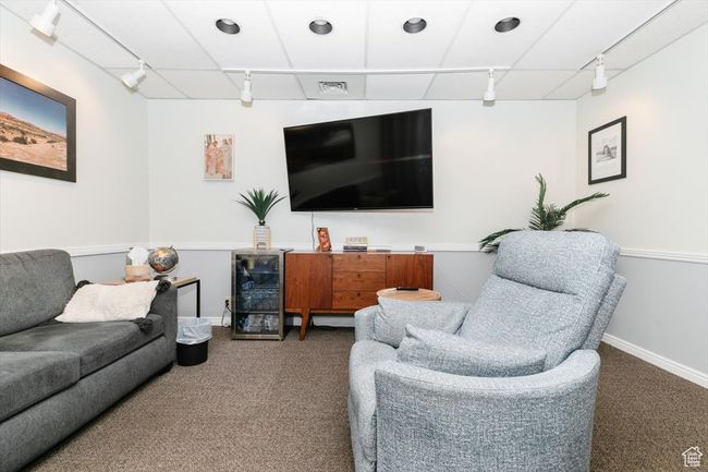 Living area with track lighting, carpet flooring, and wine cooler | Image 16