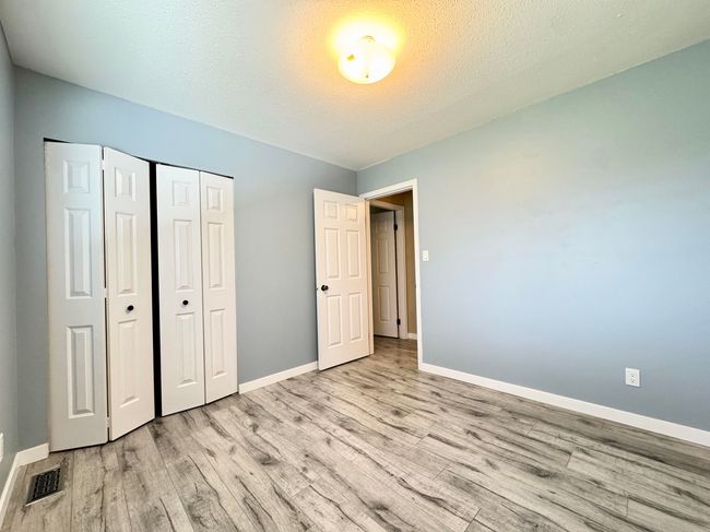 Unfurnished bedroom featuring light wood-style flooring, a closet, and a textured ceiling | Image 16