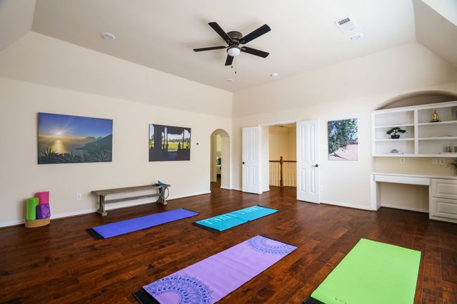 Spacious Bonus Room, lofted ceiling, wood flooring, baseboards, arched walkways, ceiling fan, built in cabinets with desk | Image 14