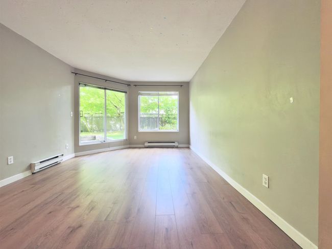 Empty room featuring a baseboard heating unit, wood finished floors, and baseboards | Image 8