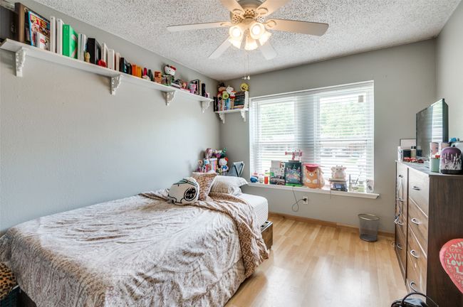 Bedroom with a textured ceiling, light wood finished floors, and a ceiling fan | Image 17