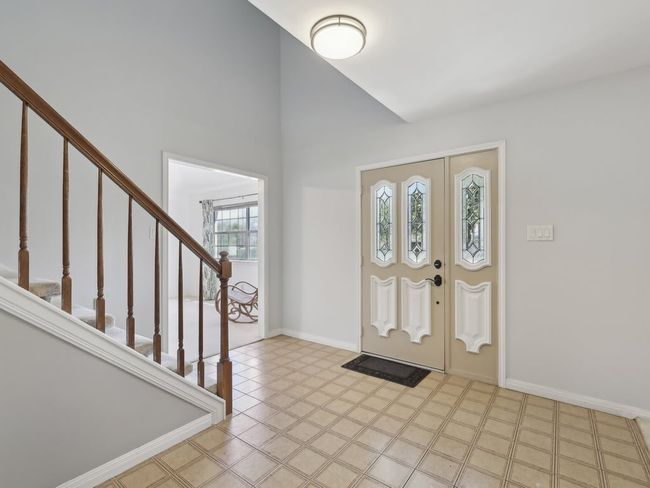 Entryway featuring a towering ceiling, baseboards, and stairs | Image 4