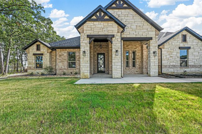 French country inspired facade featuring a front lawn, roof with shingles, and brick siding | Image 5