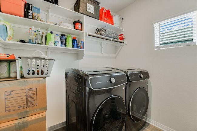 Laundry room featuring washing machine and clothes dryer, baseboards, and wood finished floors | Image 10