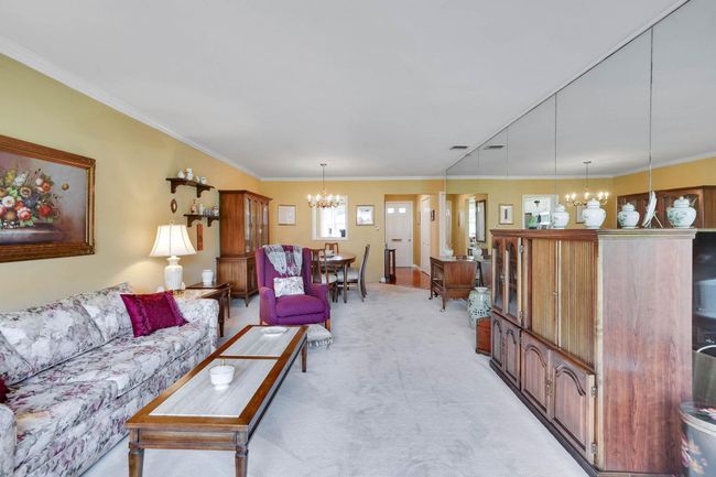 Living room featuring a chandelier, light carpet, and crown molding | Image 6