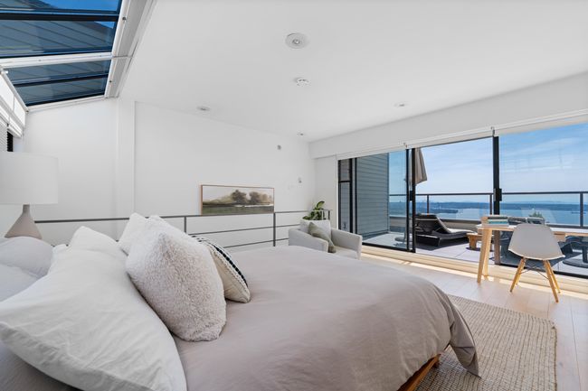 Bedroom with wood finished floors and a water view | Image 6