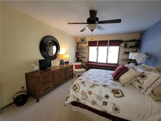 Bedroom featuring a ceiling fan and light carpet | Image 43