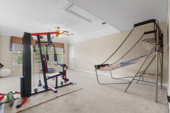 Exercise room with attic access, carpet, ceiling fan, and baseboards | Image 26