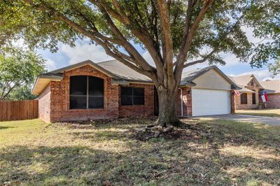 Ranch-style home with a garage and a front lawn | Image 1