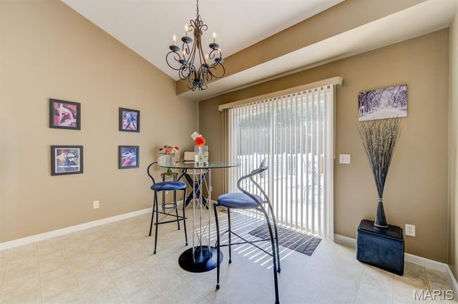 This dining area is spacious and has a beautiful chandelier. | Image 13