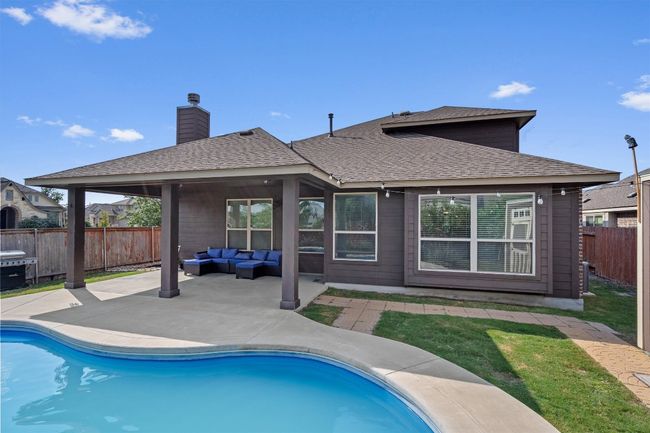 Rear view of property with an outdoor living space, a patio, a fenced backyard, a chimney, and a shingled roof | Image 26