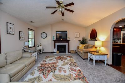 Living room featuring ceiling fan, lofted ceiling, and light carpet | Image 2