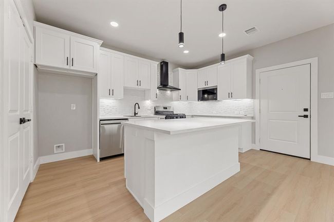 Connected living and dining. The open floor plan allows for easy flow from the kitchen to the living and dining areas, ideal for hosting guests. | Image 8