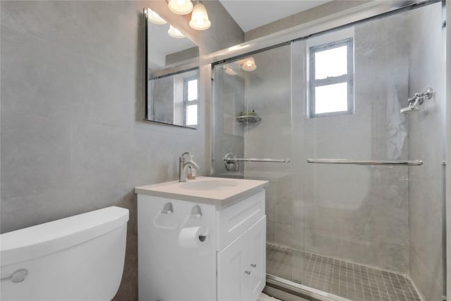 Bathroom featuring tile walls, vanity, and a stall shower | Image 10