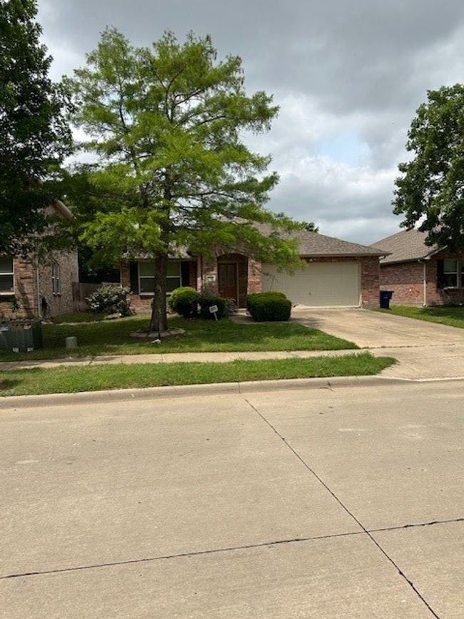 Obstructed view of property featuring concrete driveway, brick siding, a garage, and a front​​‌​​​​‌​​‌‌​‌‌​​​‌‌​​‌‌​‌​​​​​‌ yard | Image 19