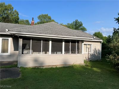 Back of property featuring a lawn and a sunroom | Image 2