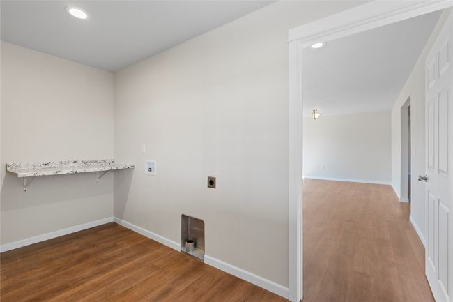 Laundry area with hookup for an electric dryer, hookup for a washing machine, baseboards, laundry area, and wood finished floors | Image 58