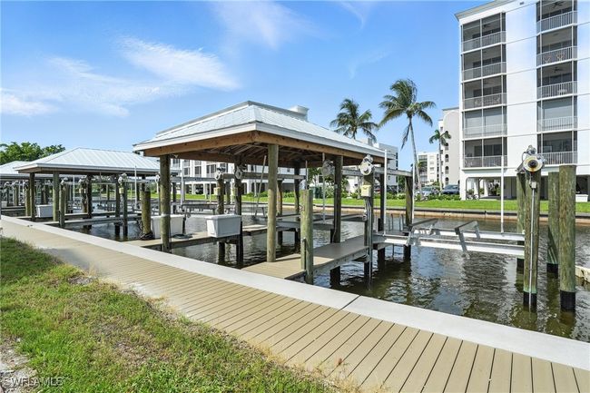 Dock area featuring boat lift and a water view | Image 35
