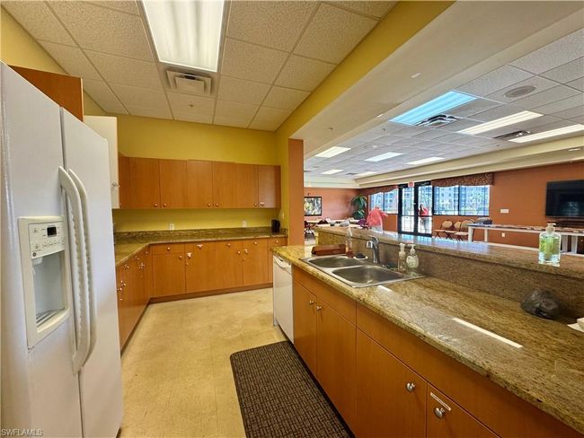 Kitchen with a sink, a drop ceiling, white appliances, and light floors | Image 32