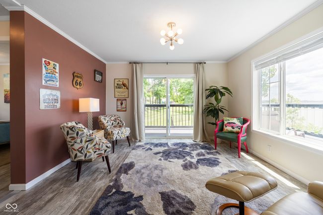 sitting room with healthy amount of natural light, ornamental molding, wood finished floors, and baseboards | Image 10