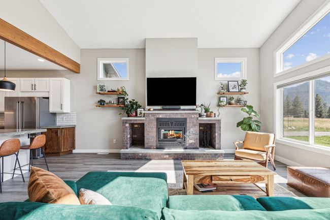Living area featuring healthy amount of natural light, a fireplace, wood finished floors, baseboards, and recessed lighting | Image 15