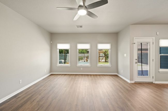 Unfurnished room featuring wood finished floors, ceiling fan, healthy amount of natural light, and baseboards | Image 8