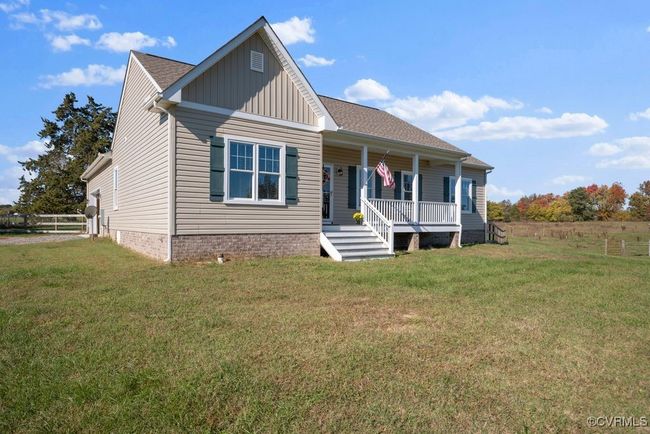 View of front facade featuring a front yard, a porch, a shingled roof, and board and batten siding | Image 39