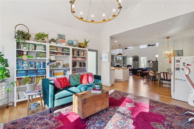 Living area featuring an inviting chandelier, wood finished floors, and vaulted ceiling | Image 14