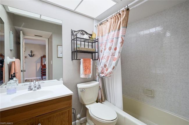 Full bathroom with vanity, a toilet, and shower / bath combo with shower curtain | Image 12