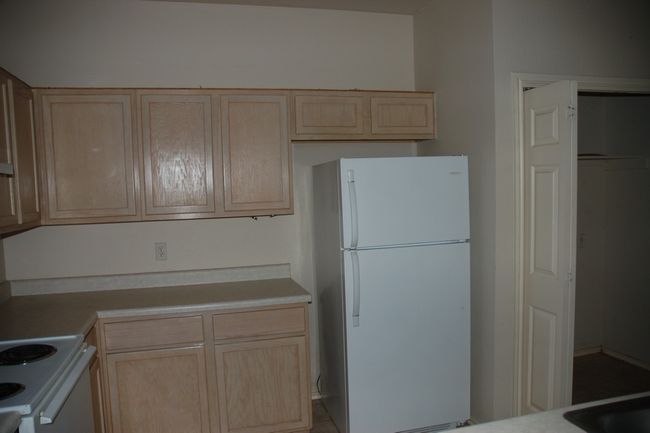 Kitchen featuring white appliances, light brown cabinets, and light countertops | Image 6