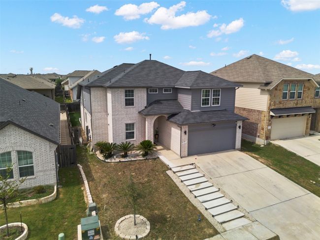 View of front of home featuring concrete driveway, brick siding, an attached garage, roof with shingles, and a residential view | Image 33