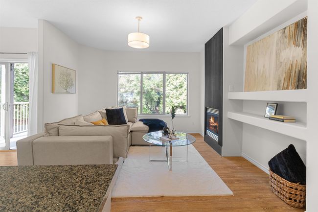 Living area with light wood-style flooring, a large fireplace, and baseboards | Image 10