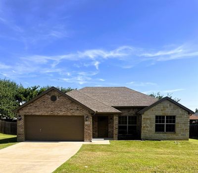 Ranch-style house with a garage and a front lawn | Image 1