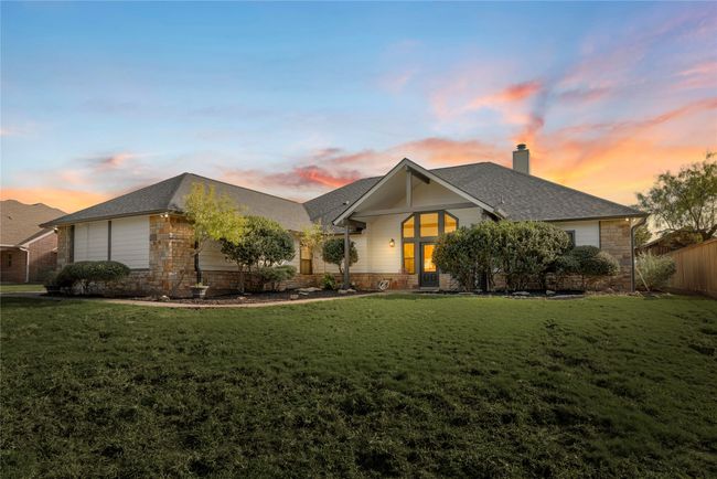 View of front of house with stone siding, a chimney, a lawn, and roof with shingles | Image 39