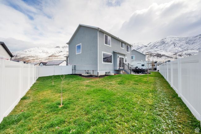 Rear view of property with a mountain view, a fenced backyard, and a yard | Image 28