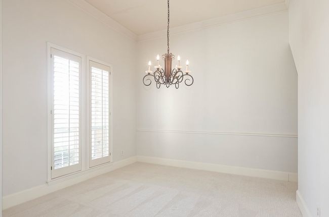 Dining room featuring a chandelier, crown molding, a healthy amount of sunlight, and carpet flooring | Image 16