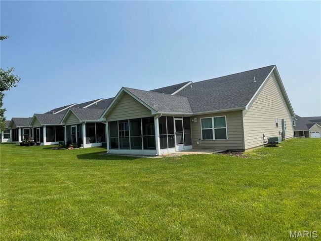 Rear view of property with a sunroom, a yard, and a shingled roof | Image 22